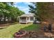 Backyard with a cozy porch, fire pit, and lush green grass at 103 Pine Meadows Cir, Hickory, NC 28601