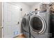 Laundry room with a modern washer and dryer, a dog door and extra storage space at 103 Pine Meadows Cir, Hickory, NC 28601