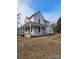 Two-story home featuring a red roof and an inviting wrap-around porch, perfect for outdoor living and relaxation at 105 E Second Ave, Mount Gilead, NC 27306