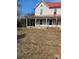 Two-story home featuring a red roof and a welcoming porch with brick base, perfect for enjoying the outdoors at 105 E Second Ave, Mount Gilead, NC 27306