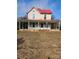 Charming two-story home with a red roof and inviting wrap-around porch, blending classic design with outdoor living at 105 E Second Ave, Mount Gilead, NC 27306