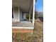 Inviting side porch with classic white columns and brick base, perfect for relaxing outdoors on a sunny day at 105 E Second Ave, Mount Gilead, NC 27306