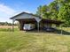 Metal barn featuring a recreational vehicle and farm implements, offering ample storage and utility at 1160 Redmon Rd, Cleveland, NC 27013