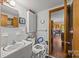 Bright bathroom with white tile, safety modifications, and adjacent rooms at 1160 Redmon Rd, Cleveland, NC 27013