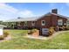 Rear exterior view showcasing the brick facade, metal roof, and well-maintained lawn at 1160 Redmon Rd, Cleveland, NC 27013