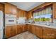 Charming kitchen with wood cabinets, white appliances, and a window view at 1160 Redmon Rd, Cleveland, NC 27013
