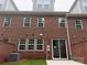 The backyard featuring a brick wall, sliding glass door, and well-maintained lawn offers a private outdoor space at 12032 Lavinia Ln, Charlotte, NC 28277