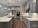 Modern kitchen boasts gray cabinets, stainless appliances, a large island, and hardwood flooring at 12032 Lavinia Ln, Charlotte, NC 28277