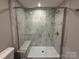 Modern bathroom shower featuring marble-look tile, glass enclosure, and a comfortable built-in bench at 12032 Lavinia Ln, Charlotte, NC 28277