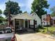 Charming home exterior features a covered porch, updated siding, a basketball hoop, and a well-maintained front yard at 1212 Meadow Ln, Charlotte, NC 28205