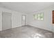 Bright bedroom featuring paneled walls, carpeted floors, and a window bringing in natural light at 1233 E Cannon Ave, Albemarle, NC 28001