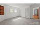 Bright bedroom showcasing built-in shelving, double closets, and access to the hallway with hardwood floors at 1233 E Cannon Ave, Albemarle, NC 28001