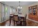 Inviting dining room with a wooden table, elegant chandelier, and natural light from the window at 1233 E Cannon Ave, Albemarle, NC 28001