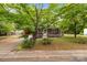 Quaint home with a screened porch, framed by lush trees and a well-maintained lawn at 1233 E Cannon Ave, Albemarle, NC 28001