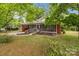 Welcoming brick home featuring a covered front porch with ramp and well-maintained lawn at 1233 E Cannon Ave, Albemarle, NC 28001