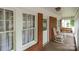 Cozy covered porch with white rocking chairs, a swing, and brick accents providing a relaxing outdoor space at 1233 E Cannon Ave, Albemarle, NC 28001