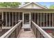 Charming front porch with screened windows and a wooden ramp, creating a welcoming entrance at 1233 E Cannon Ave, Albemarle, NC 28001