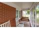 Relaxing screened-in porch features a wooden swing and comfortable white rocking chairs for enjoying the outdoors at 1233 E Cannon Ave, Albemarle, NC 28001