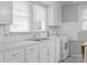 Efficient kitchen showcasing white cabinetry, stainless steel sink, double window, and modern appliances at 1233 E Cannon Ave, Albemarle, NC 28001