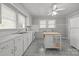 Neutral kitchen with white cabinetry, laminate countertops, double windows, and an island with seating at 1233 E Cannon Ave, Albemarle, NC 28001