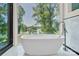 Bright bathroom showcasing modern soaking tub next to a picture window with beautiful lake views at 124 Clipper Ln, Mooresville, NC 28117