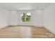 A bright and airy bedroom features hard wood floors and a large window at 124 Clipper Ln, Mooresville, NC 28117