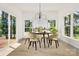 Bright dining room featuring modern chandelier, light wood floors, and views to a treed backyard at 124 Clipper Ln, Mooresville, NC 28117