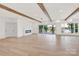 Spacious living room with hardwood floors, modern fireplace, large windows with lake views, and stylish lighting fixtures at 124 Clipper Ln, Mooresville, NC 28117