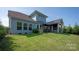 A beautifully landscaped backyard featuring a patio with outdoor dining and a view of the home's exterior at 1260 Thomas Knapp Pkwy, Fort Mill, SC 29715