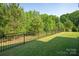 Spacious backyard with lush green grass and a black iron fence, offering privacy and a secure outdoor space at 1260 Thomas Knapp Pkwy, Fort Mill, SC 29715