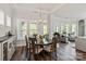 Elegant dining area with large windows, a wooden table set, and a view into the living room at 1260 Thomas Knapp Pkwy, Fort Mill, SC 29715