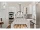 Modern kitchen featuring stainless steel appliances, granite countertops, white cabinetry, and wood flooring at 1260 Thomas Knapp Pkwy, Fort Mill, SC 29715