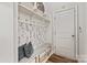 Mudroom featuring storage shelves, hooks, a bench with storage, and decorative wallpaper at 1260 Thomas Knapp Pkwy, Fort Mill, SC 29715
