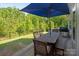 Backyard with outdoor dining area featuring a large table, built-in grill, and a blue umbrella for shade at 1260 Thomas Knapp Pkwy, Fort Mill, SC 29715