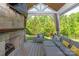 Inviting outdoor living space featuring a stone fireplace, comfortable seating, and lush backyard views at 1260 Thomas Knapp Pkwy, Fort Mill, SC 29715