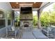 Inviting outdoor living space featuring a stone fireplace, comfortable seating, and a view of the manicured backyard at 1260 Thomas Knapp Pkwy, Fort Mill, SC 29715