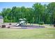 A community playground sits on a large grassy lawn surrounded by a black mulch and green trees at 1260 Thomas Knapp Pkwy, Fort Mill, SC 29715