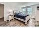 Bright bedroom featuring wood-look flooring, a ceiling fan, and a large window allowing for plenty of natural light at 128 Championship Dr, Mooresville, NC 28115