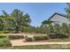 Bocce ball court featuring a bench and canopy, surrounded by a sidewalk, grass, and shrubbery at 128 Championship Dr, Mooresville, NC 28115