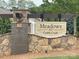 Elegant stone community entrance sign at Meadows at Coddle Creek with manicured landscaping at 128 Championship Dr, Mooresville, NC 28115