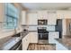 Bright kitchen features granite countertops, stainless appliances and wood-look floors at 128 Championship Dr, Mooresville, NC 28115