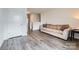Open living space with wood-look flooring, a neutral-colored sofa, and bright white walls at 128 Championship Dr, Mooresville, NC 28115