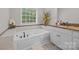Primary bathroom featuring a large soaking tub with tile surround and a window for natural light at 130 Churchill Dr, Salisbury, NC 28144