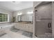 Bathroom showcasing a double sink vanity, a large mirror, glass enclosed shower and a soaking tub at 130 Churchill Dr, Salisbury, NC 28144