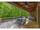 A covered outdoor deck with a ceiling fan provides shade for dining and relaxation, overlooking a private backyard at 130 Churchill Dr, Salisbury, NC 28144