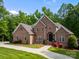 Stately brick home with a circular driveway, manicured lawn, and attractive landscaping at 130 Churchill Dr, Salisbury, NC 28144