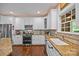 Bright kitchen featuring granite counters, white cabinets, and stainless-steel appliances with window at 130 Churchill Dr, Salisbury, NC 28144