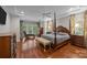 Main bedroom with hardwood floors, 4-poster bed, bench, and lots of natural light through multiple windows at 130 Churchill Dr, Salisbury, NC 28144