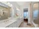Bathroom with double vanity, quartz countertops, tiled shower, and access to the bedroom at 13714 Jacks Ln, Pineville, NC 28134