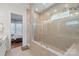 Tiled walk-in shower with glass door and view to the bedroom at 13714 Jacks Ln, Pineville, NC 28134